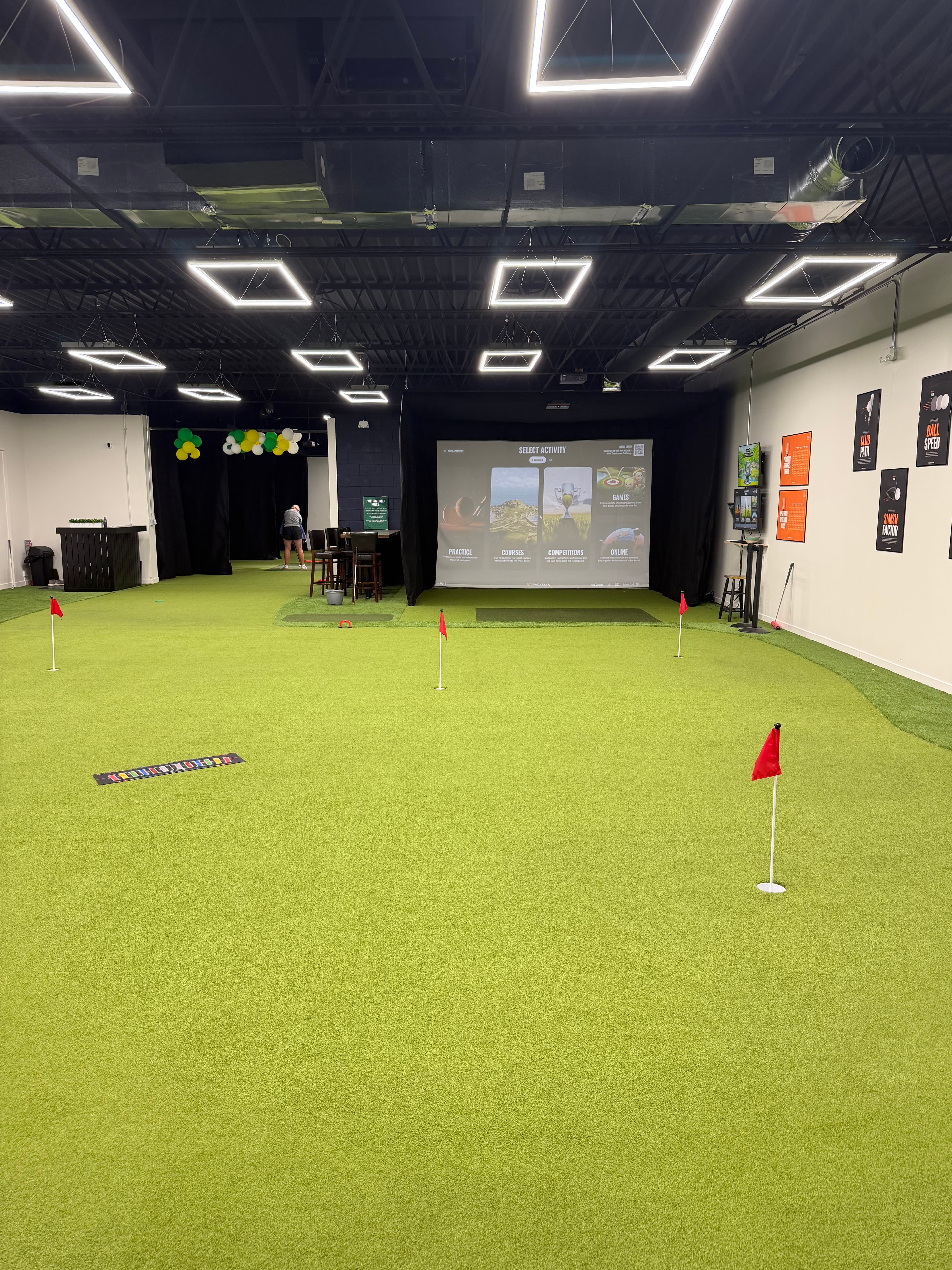 Better Golf QC indoor training facility with TrackMan bays and a putting green